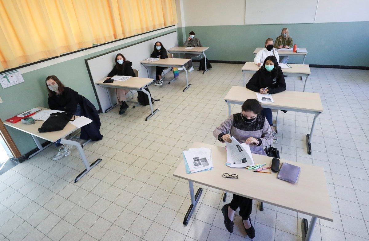 Students wearing protective face masks sit in a classroom at a flemish secondary school during its reopening in Brussels, as a small part of Belgian children head back to their schools with new rules and social distancing measures, during the outbreak of the coronavirus disease (COVID-19), in Brussels, Belgium, May 15, 2020. REUTERS/Yves Herman