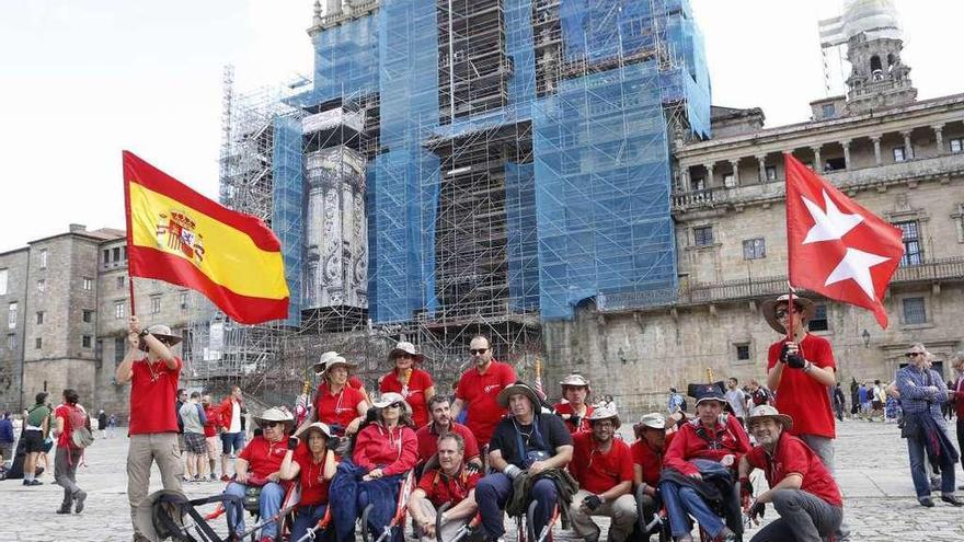 Caballeros de la Orden de Malta con peregrinos en sillas de ruedas especiales ayer en Santiago. // Xoán A.