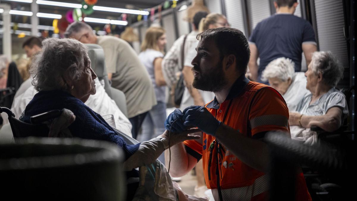 Un sanitario atiende a una anciana en la residencia Domus Vi Zalfonada de Zaragoza.