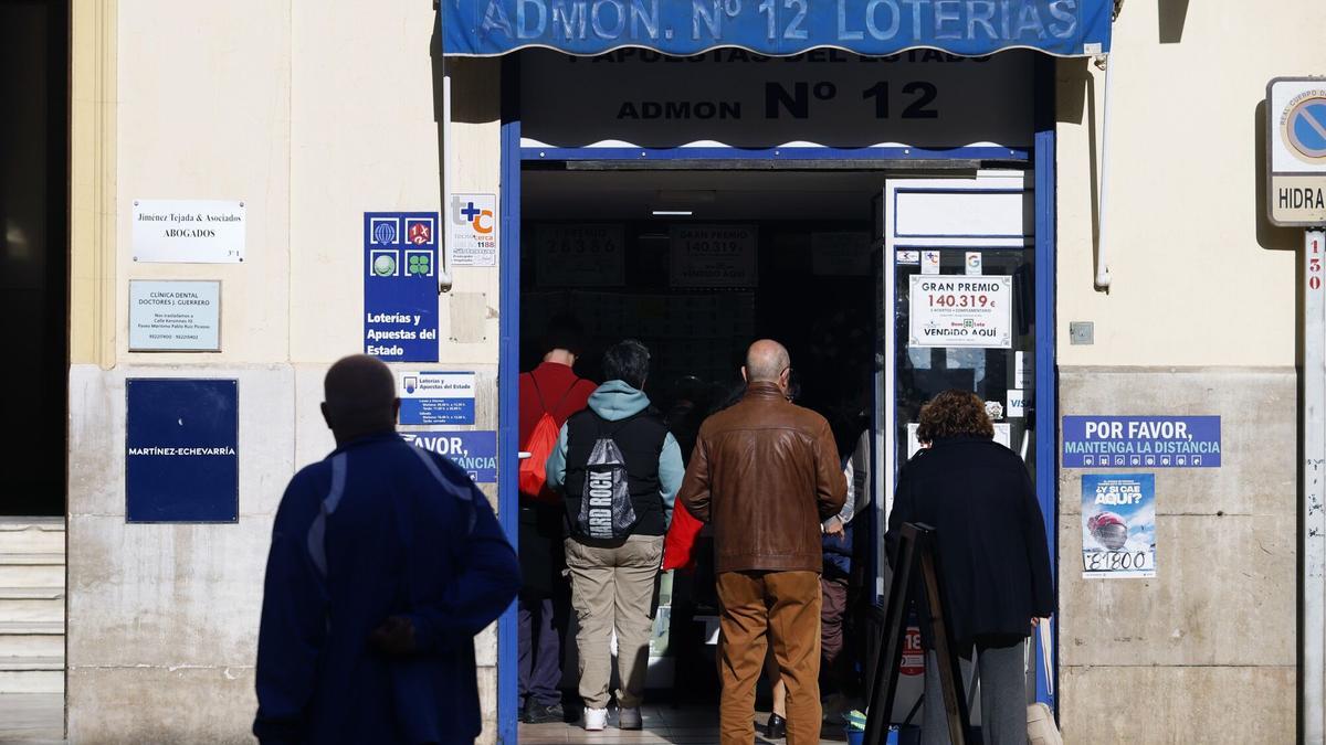 Varias personas hacen cola para comprar décimos de la Lotería de Navidad