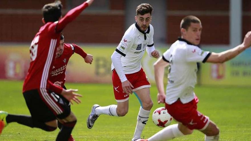 El caudalista Pelayo conduce el balón ante Borja Prieto ante dos futbolistas del Mirandés, ayer, en Anduva.