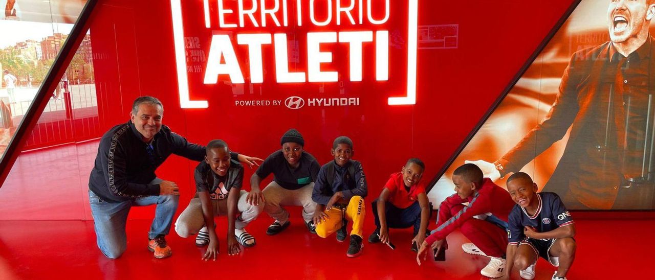 Rubén Hidalgo (izquierda) junto a un grupo de chicos aficionados al fútbol en las instalaciones del Atlético de Madrid. | Cedida