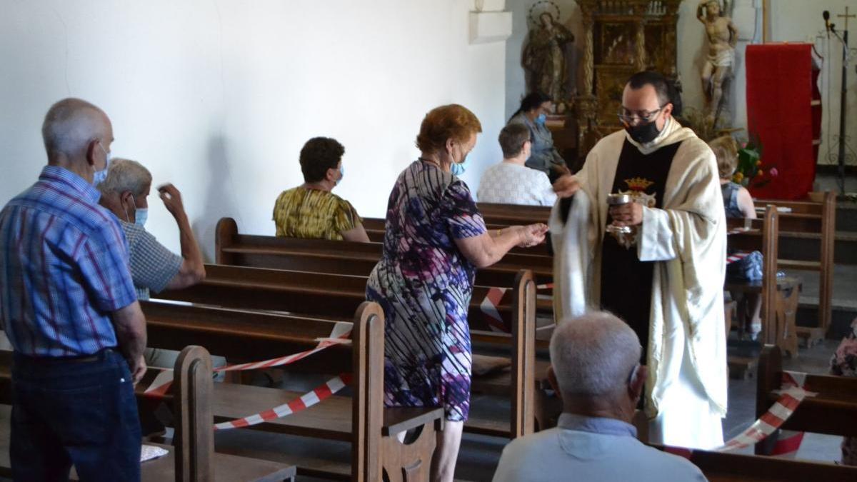 El sacerdote procede a dar la comunión a los feligreses de Pedralba