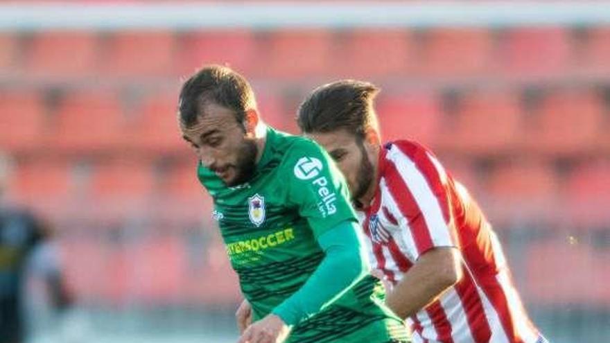 Adrián Llano se lleva el balón ante un rival en el partido contra el filial del Atlético de Madrid.