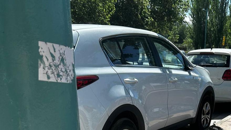 Uno de los vehículos vanzalizados en la avenida José Atarés, sin uno de los retrovisores, frente al Juzgado de Guardia de Zaragoza.