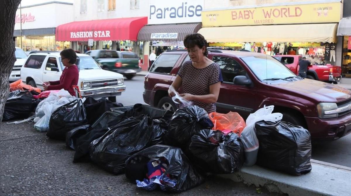 Dos mujeres mexicanas empacan las compras del día, ropa que venderán más tarde en México.