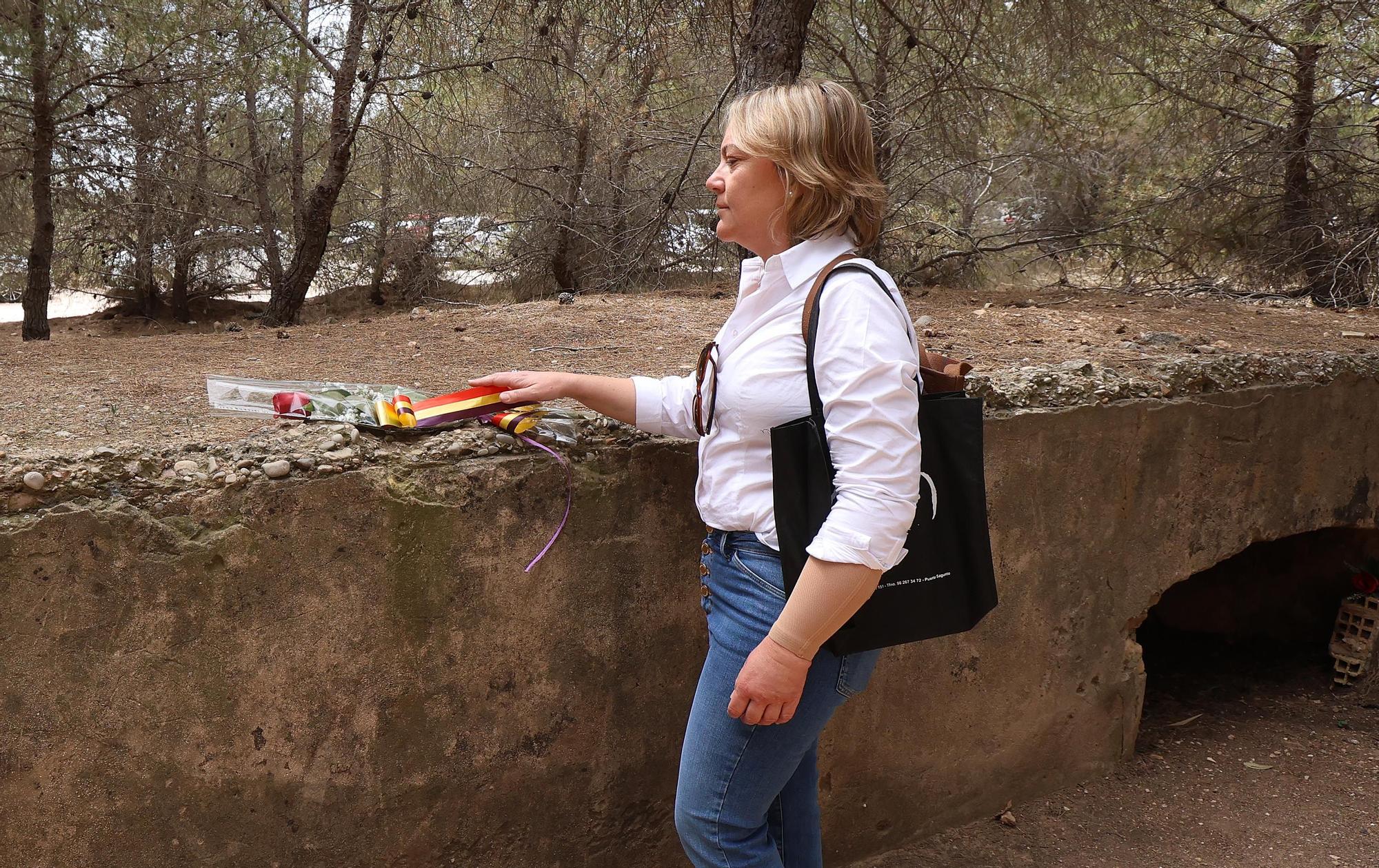 Una mujer deposita una flor sobre el Paredón de Paterna, este viernes.