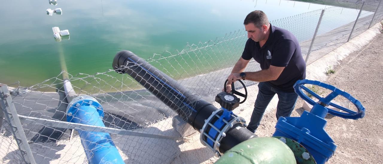 Un técnico cierra la tubería de una balsa de riego de Riegos de Levante en Rojales