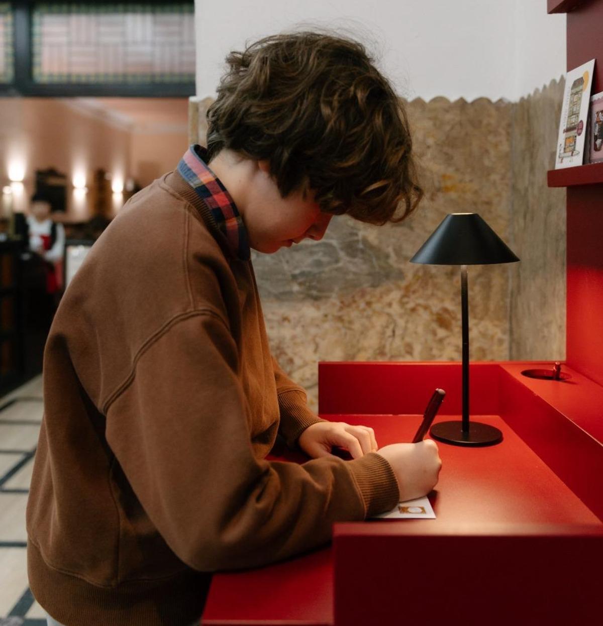 Mario Viejo escribiendo su postal.