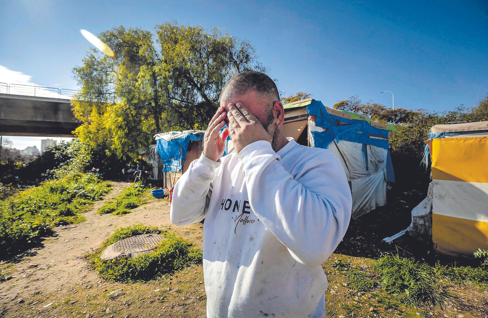 Renato cubre su rostro frente a las barracas emplazadas en el parque de sa Riera.