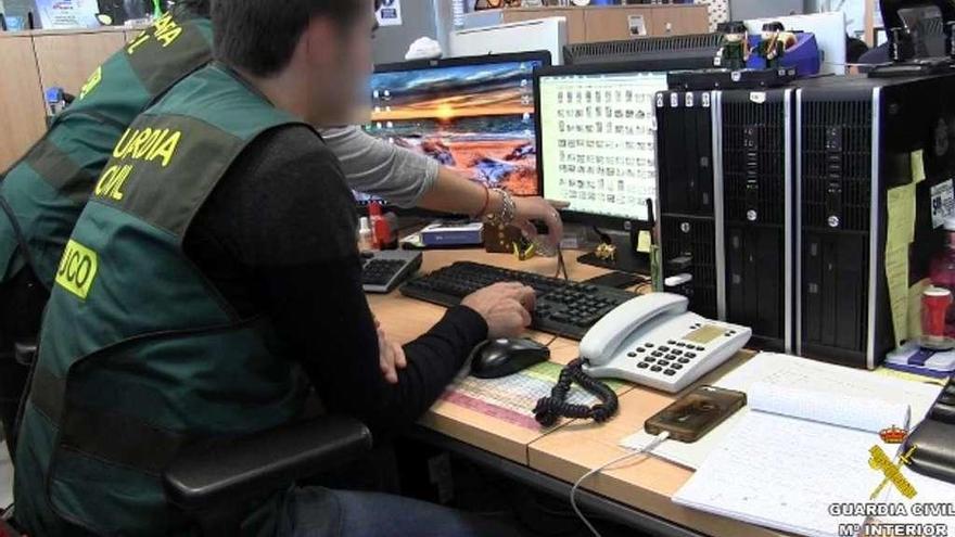 Agentes del grupo UCO de la Guardia Civil, analizando archivos incautados. // Guardia Civil