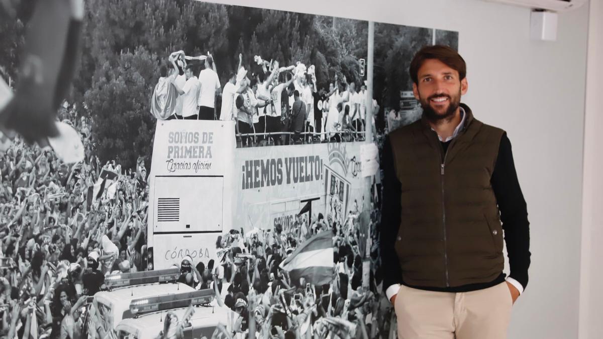 Álex Bernal posa ante una imagen de las celebraciones del ascenso a Primera en 2014.