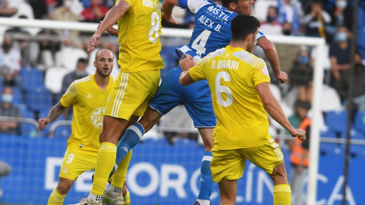 Álex salta entre dos jugadores del Badajoz en Riazor. |  // CARLOS PARDELLAS