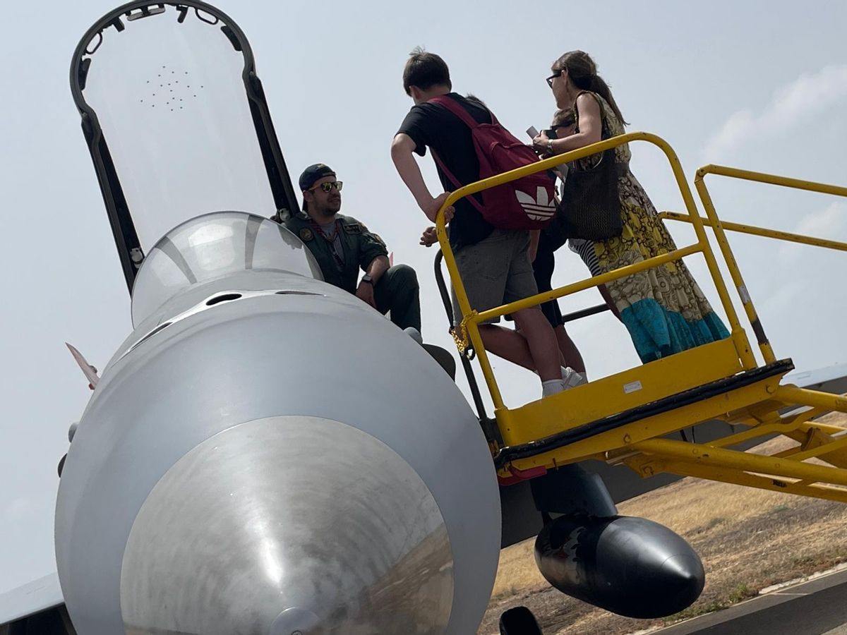 Un piloto del Ala 15 del Ejército del Aire explica la cabina del caza F18 a unos jóvenes.