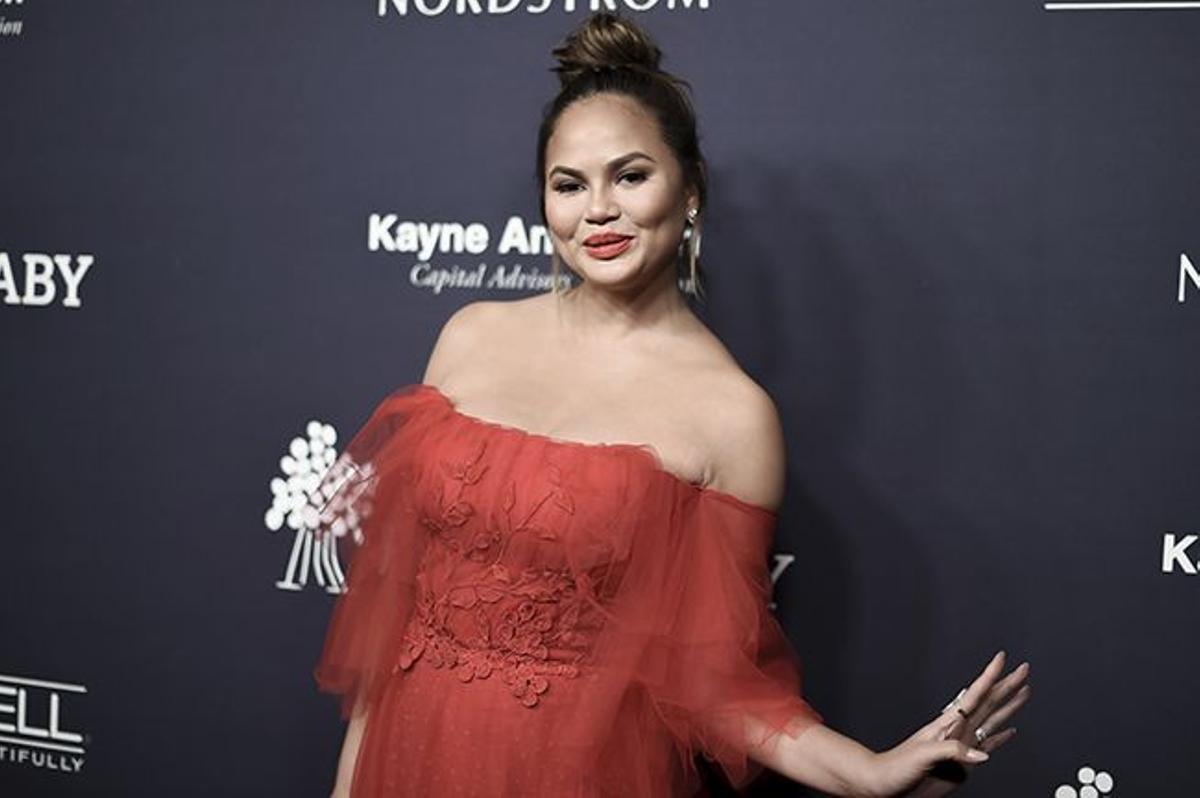 Chrissy Teigen durante una gala de premios con vestido rojo