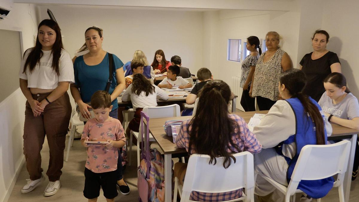 Madres y estudiantes de las clases de repaso para familias sin recursos que ofrece la Fundación Iniciativa Social en el bario de Monteolivete, en València.