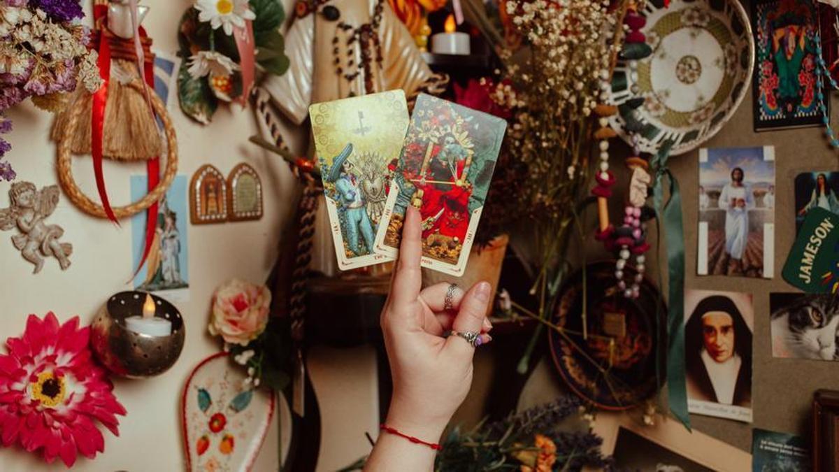 Giuliana Despósito, la tarotista de La Santoría, muestra dos cartas del tarot.