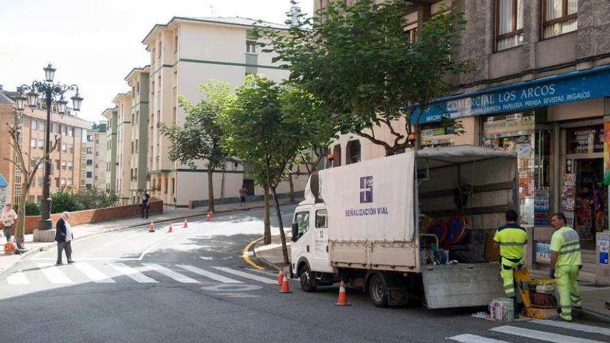 Operarios suprimiendo las plazas de aparcamiento de la calle Tito Bustillo.