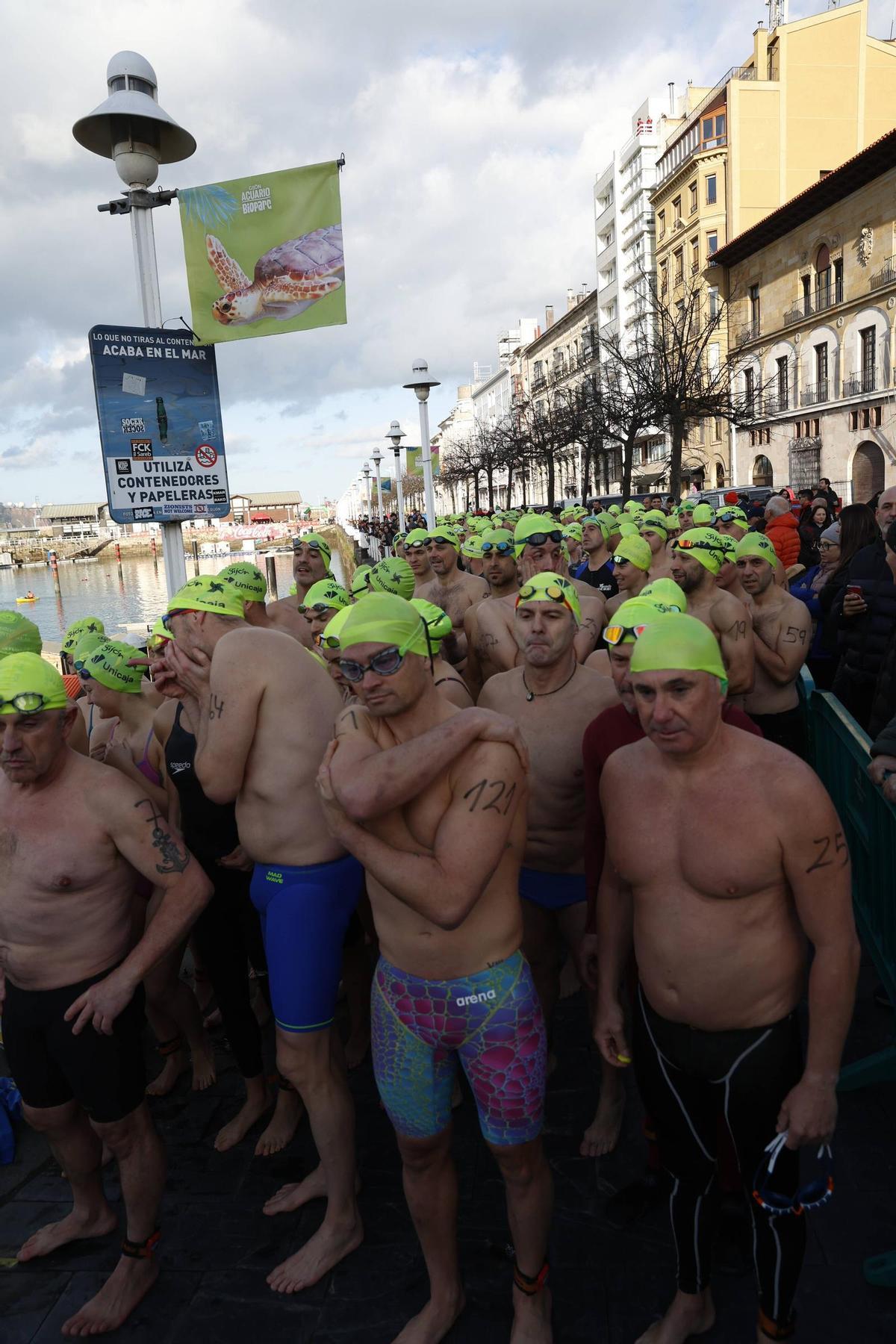 La travesía a nado de Navidad en Gijón congrega un año más a decenas de participantes (en imágenes)