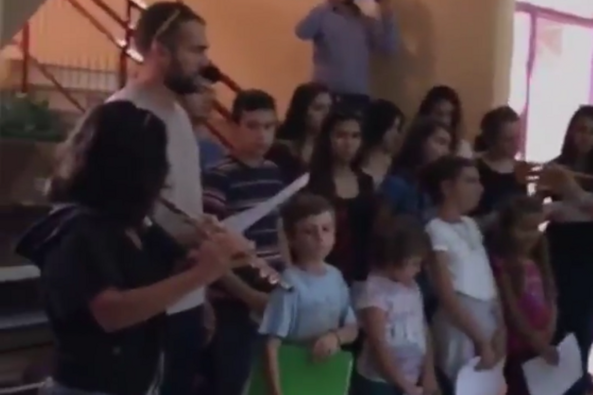 Un cor escolar canta ’L’estaca’ de Llach per donar la benvinguda als refugiats.
