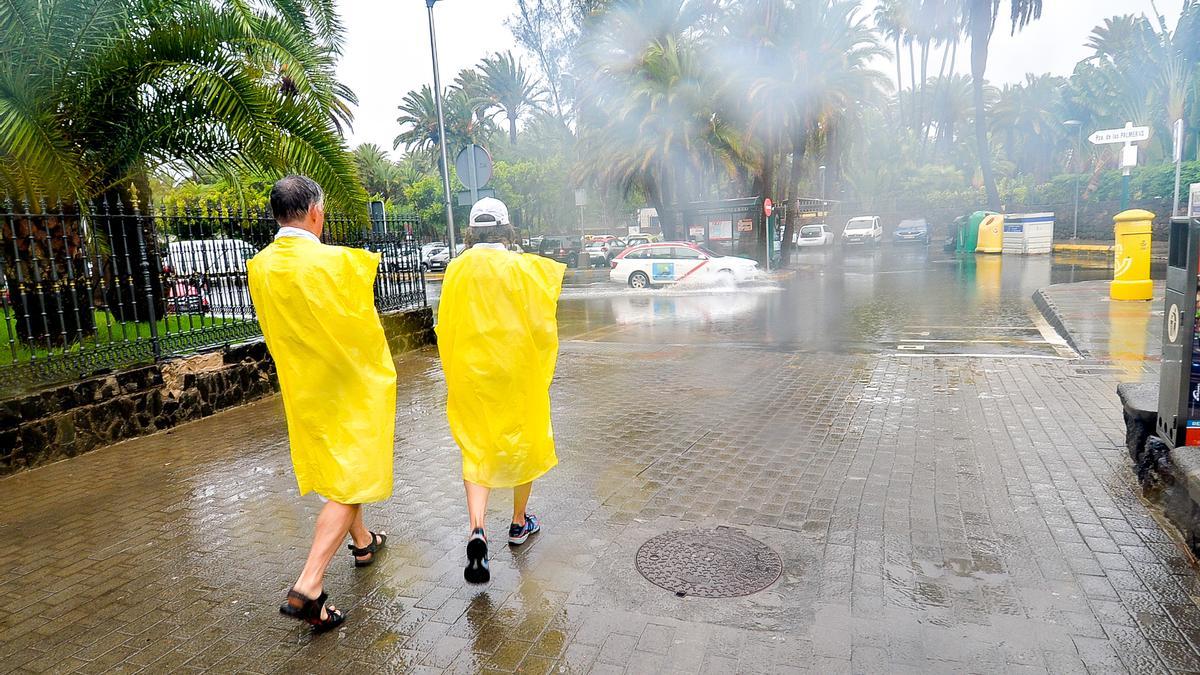 Turistas se protegen de la lluvia en el sur de Gran Canaria.