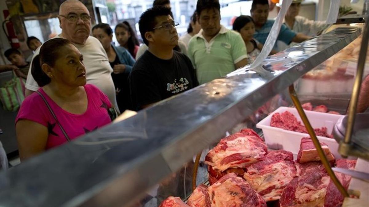 Unos clientes compran carne en un mercado de Buenos Aires.