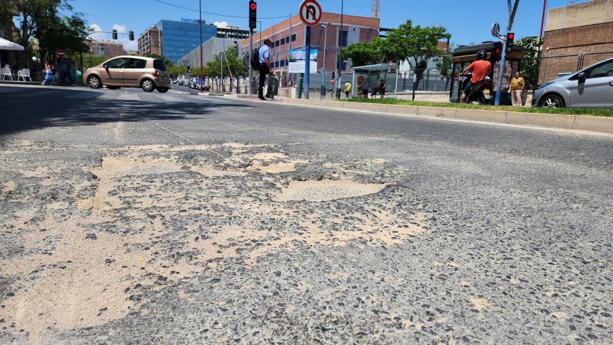 Socavón en el asfalto junto al Hospital General, en el entorno donde planta su monumento la hoguera del barrio