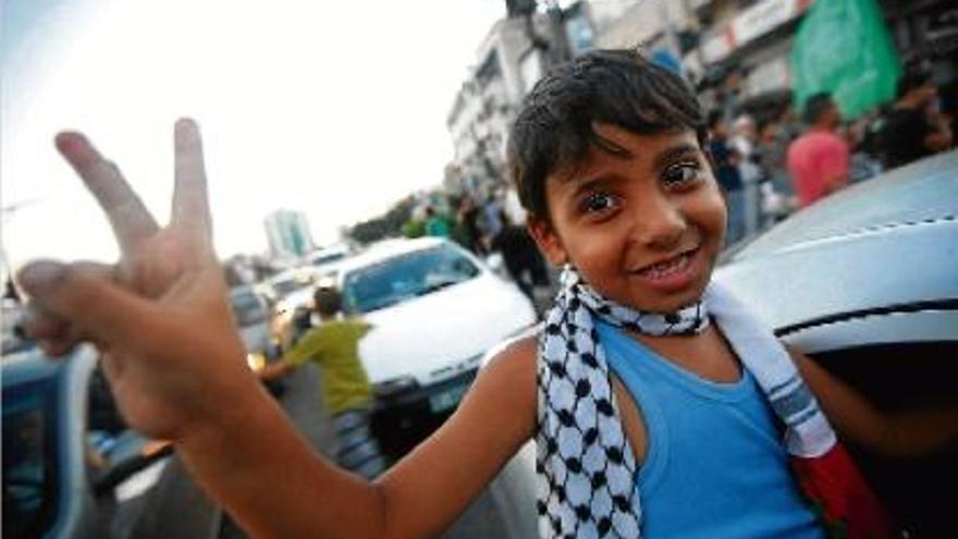 Un nen palestí fa el símbol de la victòria durant la celebració als carrers de l&#039;alto al foc a Gaza