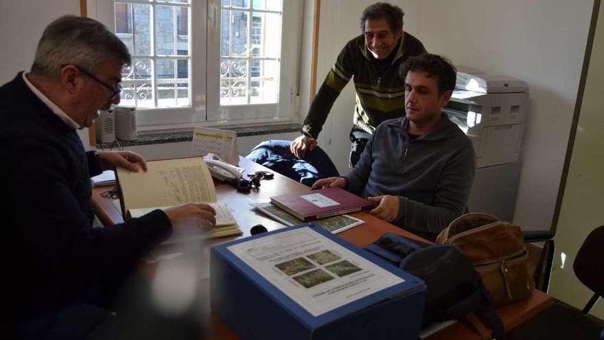 Dos concejales y el secretario del Ayuntamiento de Asturianos consultan la documentación.