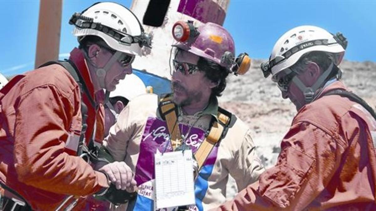 70 días a 623 metros bajo tierra. Dos miembros de los equipos de rescate intercambian impresiones con el minero Víctor Segovia, tras ser rescatado el 13 de octubre del 2010.