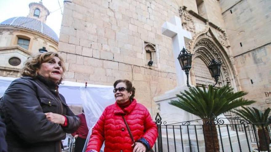 Dos señoras junto a la Cruz de los Caídos, donde los custodios hacen guardia desde hace ya más de un año.