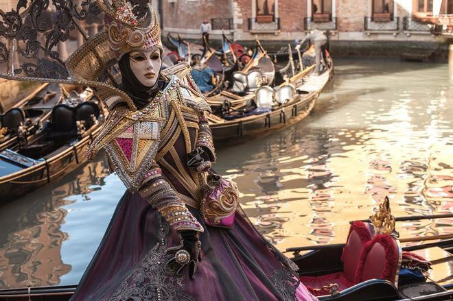 Mujer disfrazada de carnaval sobre los canales de Venecia