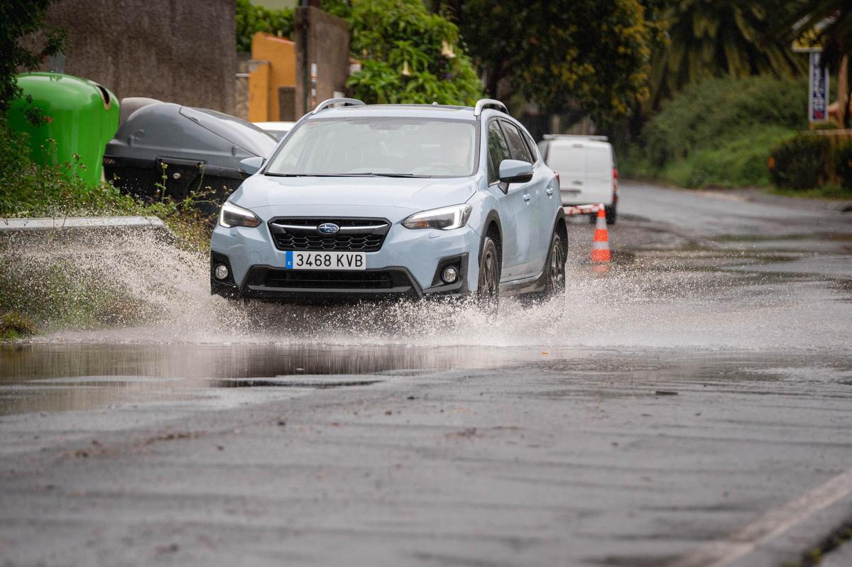 Un vehículo atraviesa una vía inundada en Tenerife.