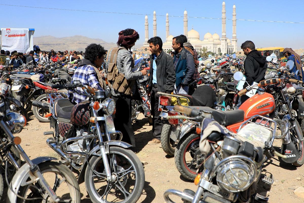 Los yemeníes se reúnen en medio de motocicletas mientras esperan que se les expidan licencias para conducir como parte de una campaña de seguridad de las autoridades huzíes, en Yemen