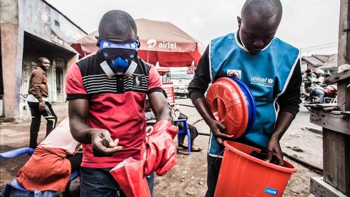 Trabajadores sanitarios se protegen para mezclar agua con cloro en Goma, este miércoles.