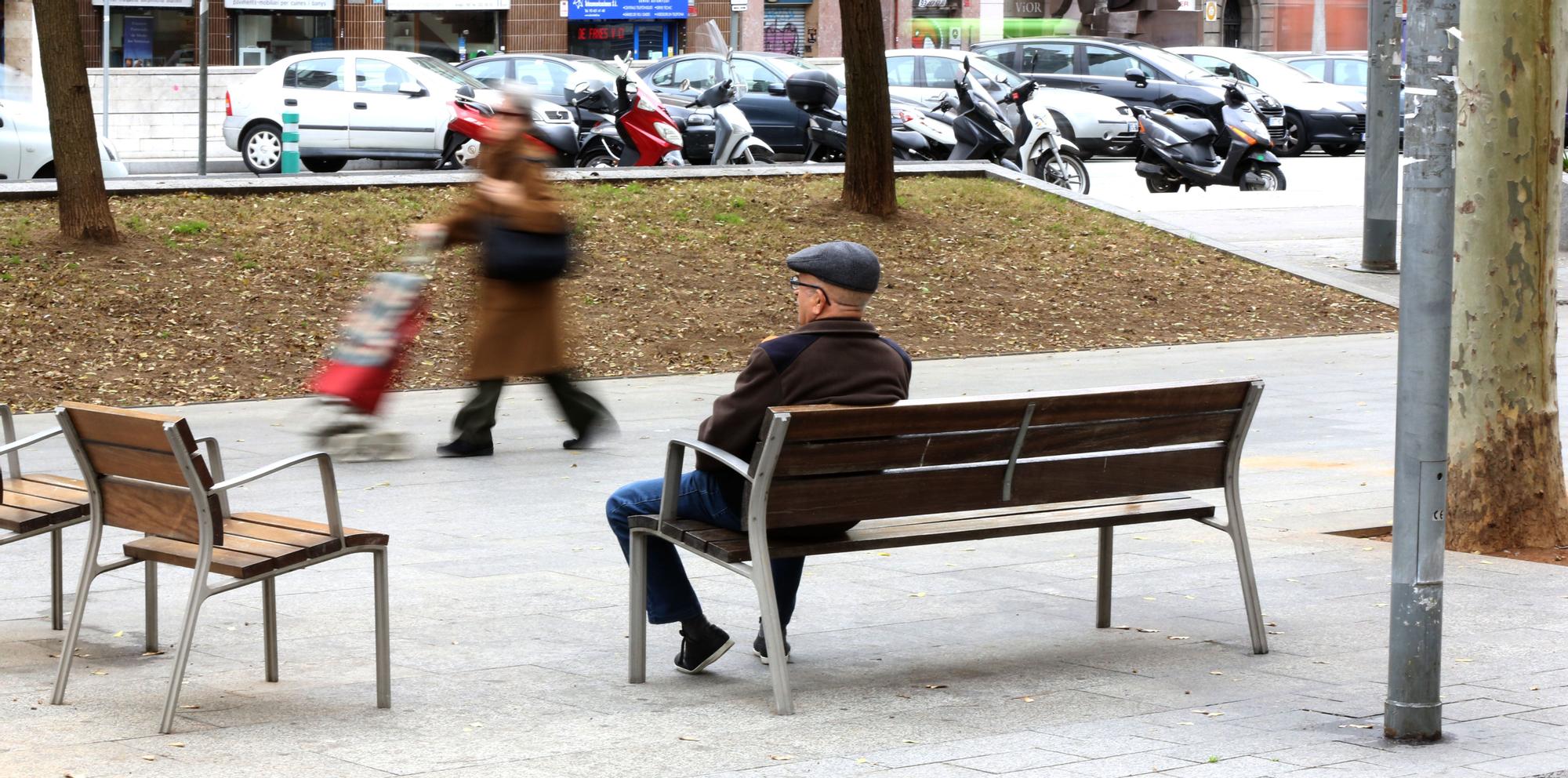 Un hombre se sienta solo en un banco en Barcelona