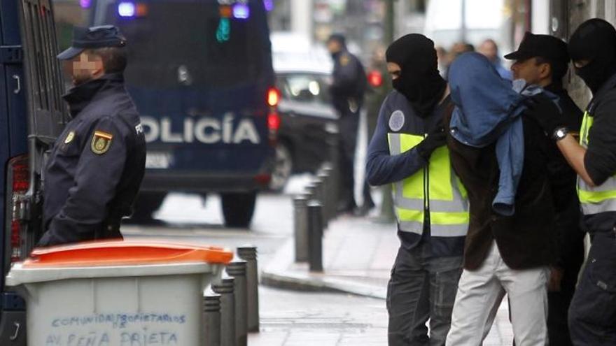 Dos agents de la Policia amb un dels detinguts, a Vallecas.