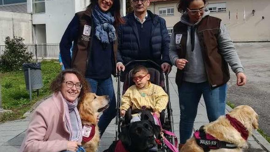 Izan, uno de los alumnos, con los dos perros, las técnicas, la edil de Ensino y el director. // D.P.