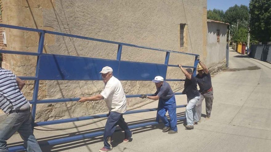 Vecinos transportan una talanquera.