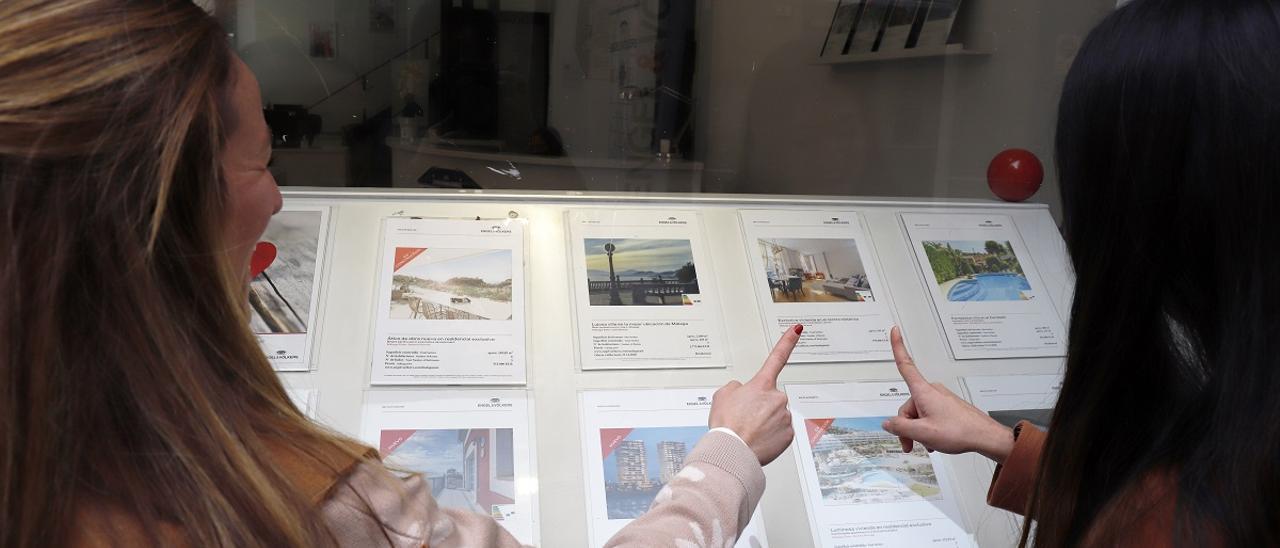 Clientes observan un escaparate de una inmobiliaria en la capital.