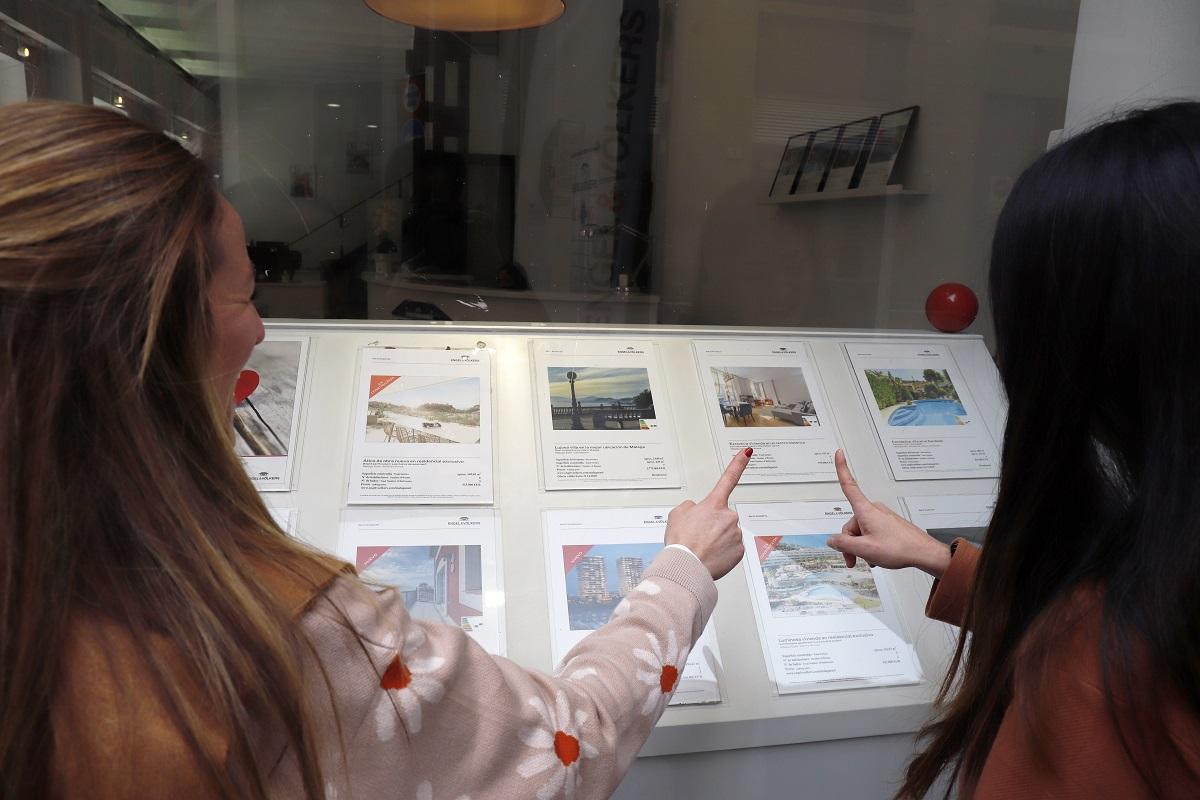 Clientes observan un escaparate de una inmobiliaria en la capital.