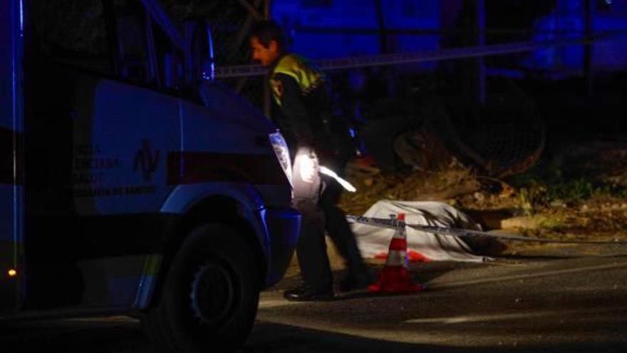 Un policía junto al cuerpo del motorista.