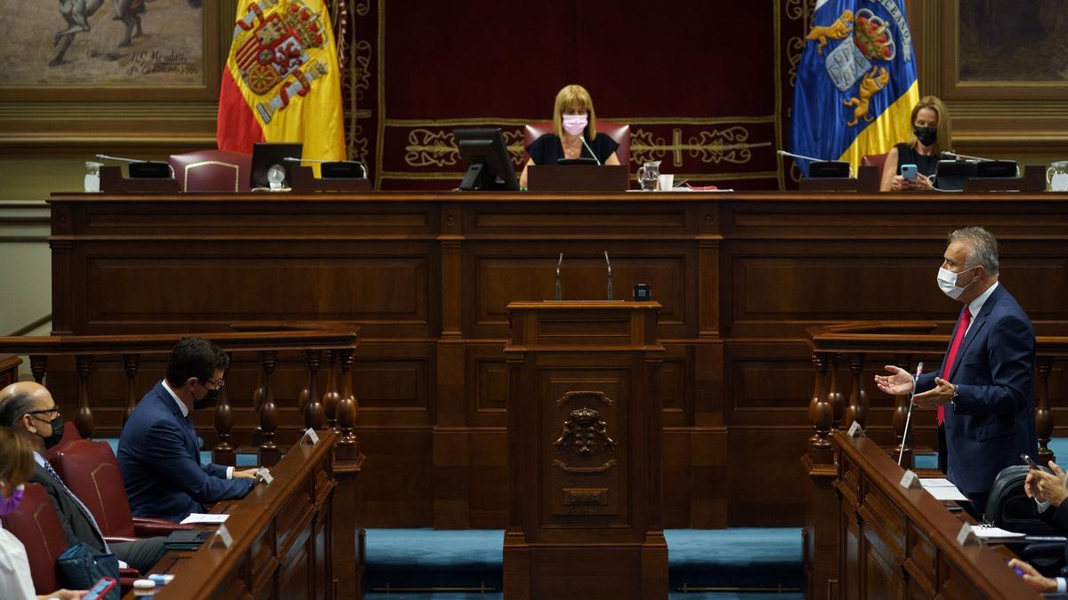 El presidente de Canarias, Ángel Víctor Torres (d), responde este jueves ante el pleno del Parlamento a preguntas de los diputados.