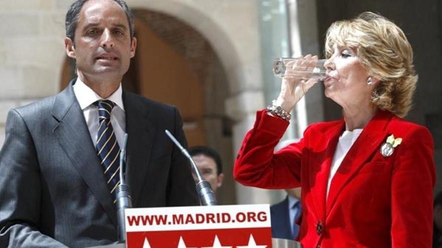 La presidenta de la Comunidad y del PP de Madrid, Esperanza Aguirre, bebe un vaso de agua, en presencia de Francisco Camps.