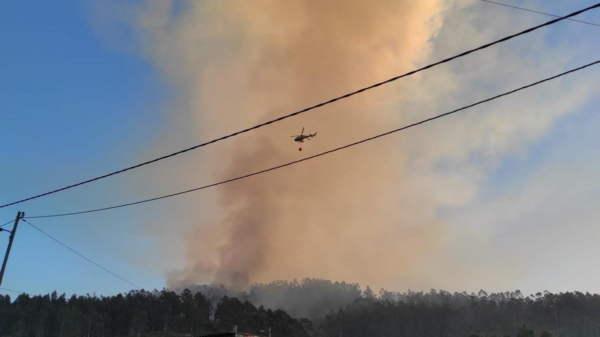 Un helicóptero, esta mañana en la zona, donde aún era visible una gran columna de humo.