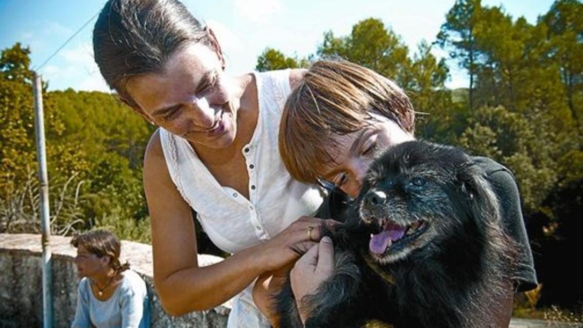 El perro Snoopy, junto a su nueva familia, ayer en el refugio La Amistad de Vallirana.