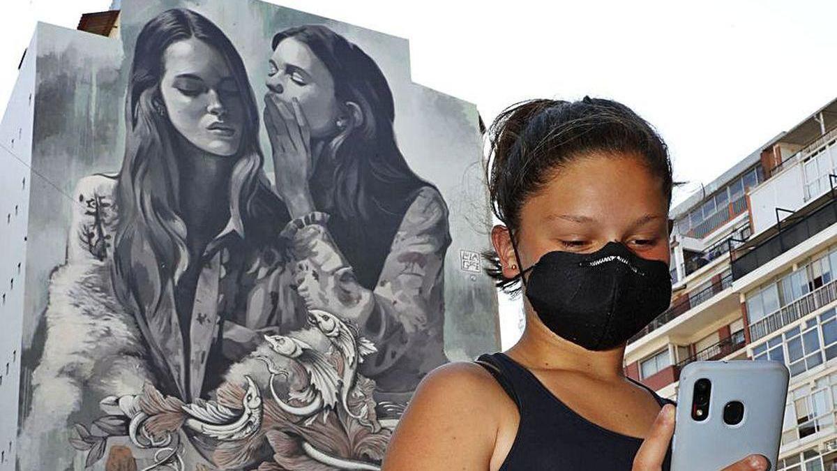 Una joven se saca un &quot;selfie&quot; ante el mural de Lula Goce.