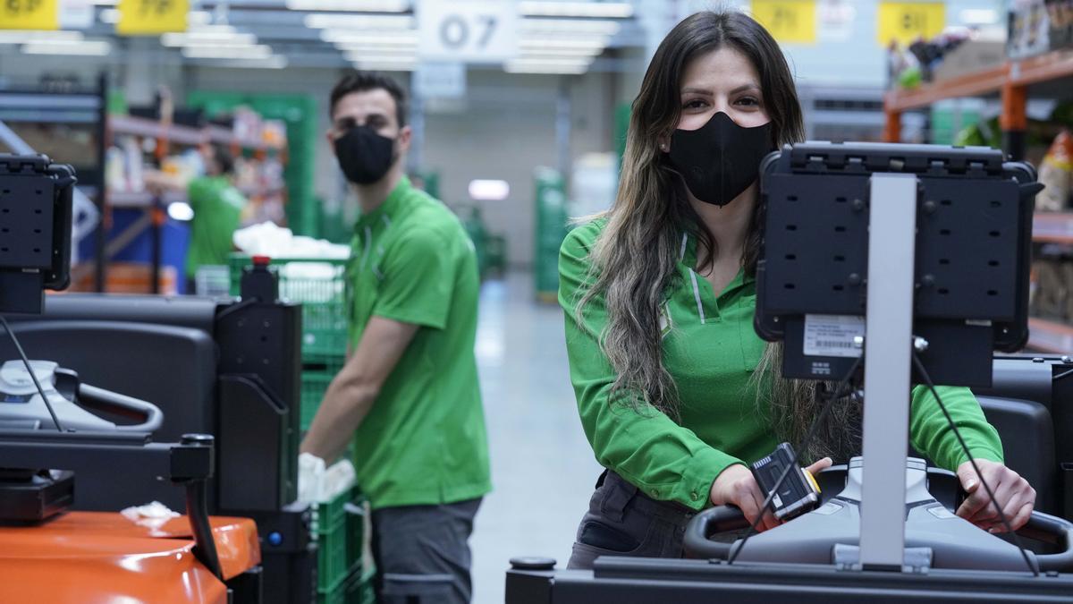 Mario y Coral, trabajadores de la Colmena de Getafe (Madrid), con la nueva mascarilla corporativa.