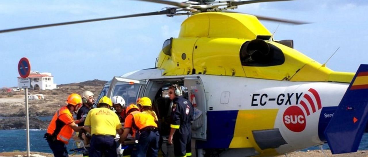Personal sanitario realiza la evacuación en el helicóptero del SUC de un herido.