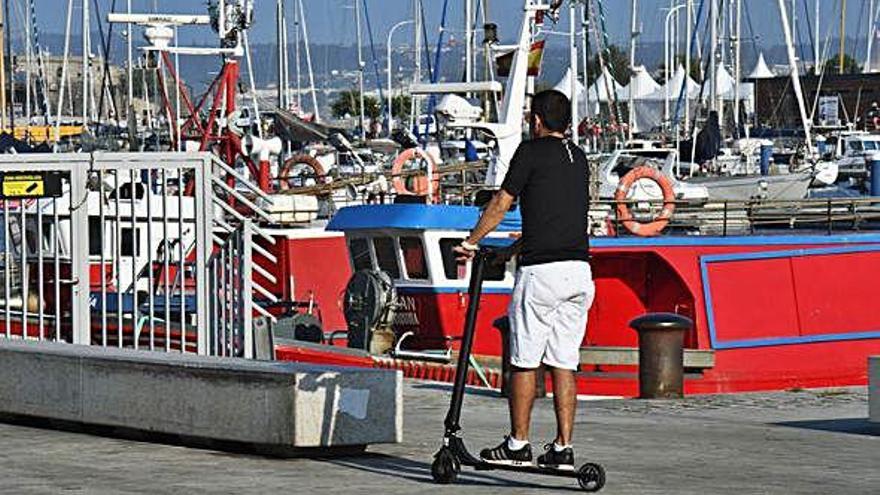 Un hombre circula por la Marina en un patinete eléctrico.